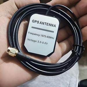 GPS Antenna External Active Antenna For GPS – 3-5V 28DB - a black square antenna with a cable ending in a gold-colored SMA connector held in a hand.