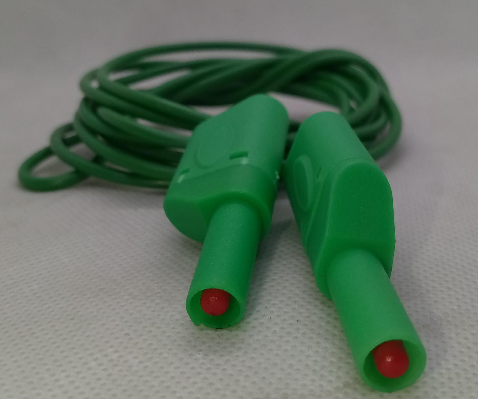 Green Banana Clip Wires 2 Meter | High-Quality Test Leads | Digilog.pk - two green banana plug connectors with red tips attached to a coiled green cable on a white background.