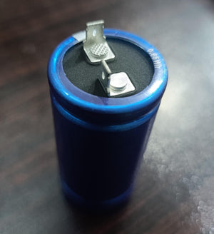 Green Cap Edlc(dB) 2.8V 600F Super Capacitor - a blue cylindrical capacitor with two metal terminal tabs on the top surface.