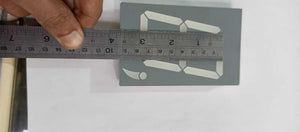 Green color 7 segment - shown from a top-down view with a metal ruler placed across its width to indicate its physical dimensions.