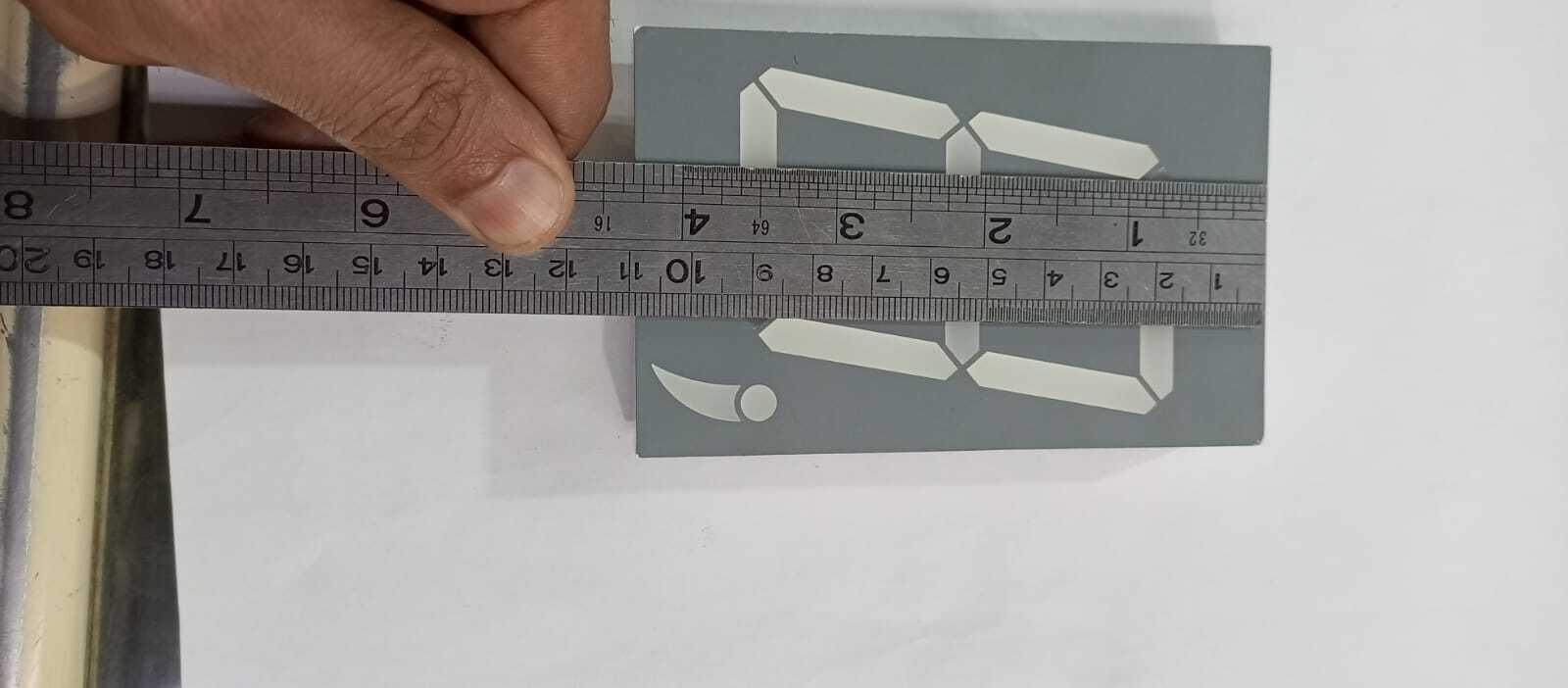 Green color 7 segment - shown from a top-down view with a metal ruler measuring its length against a white background.