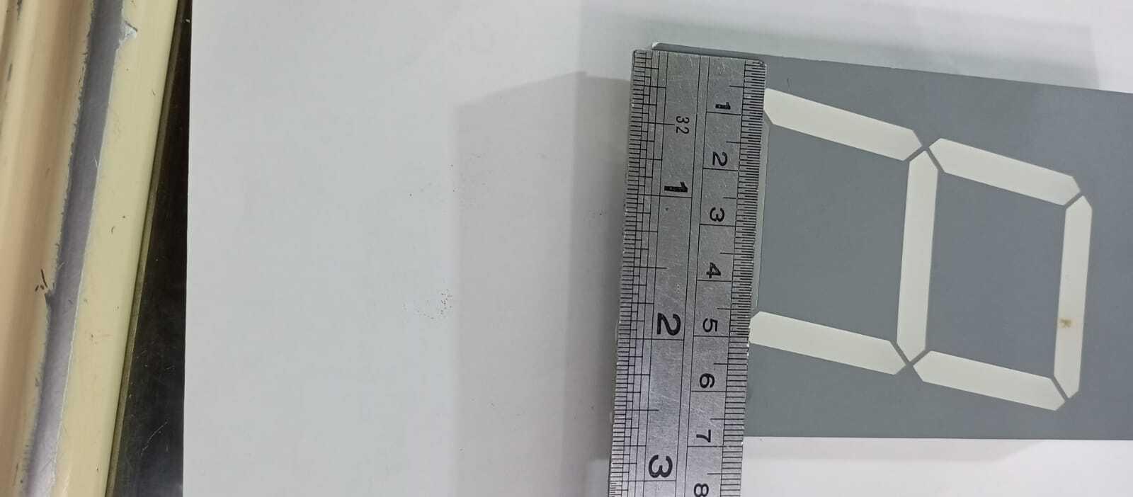 Green color 7 segment - shown in a close-up view with a metal ruler placed along the side to indicate its dimensions.