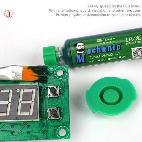 Green Mechanic UV Curable 10CC Solder Mask Ink PCB Fixing Repairing Welding Oil Paint Prevent Corrosive Arcing - tube, a green cap, and a brush applying the ink onto a green PCB with a two-digit display and buttons.