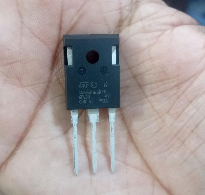 GWT80H65DFB MOSFET Transistor - a black three-pin electronic component held in a palm, with STMicroelectronics branding and text printed on its surface.