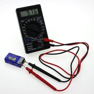 Handheld Digital Multimeter DT830B Mini LCD Voltmeter Ammeter Ohm Tester - 9.76 on its LCD screen, connected via red and black probes to a 9V battery.