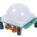 HC-SR501 PIR Motion Sensor Module Hw-416-b - a white dome lens, a green circuit board, two orange potentiometers, and two black capacitors.