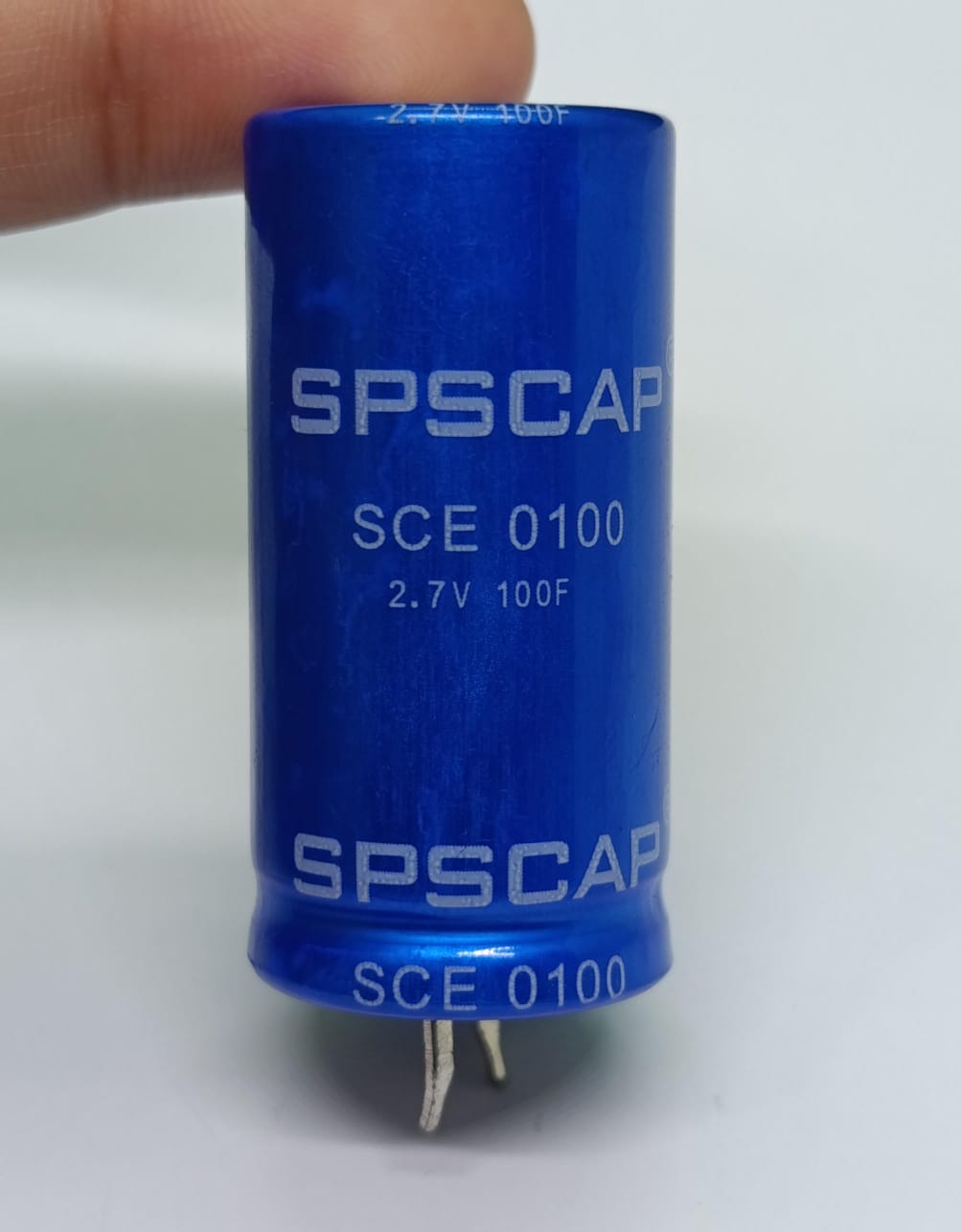 High Quality 2.7V 100F Super Capacitor - a cylindrical blue electronic component with SPSCAP and SCE 0100 printed on its body and two bottom terminals.