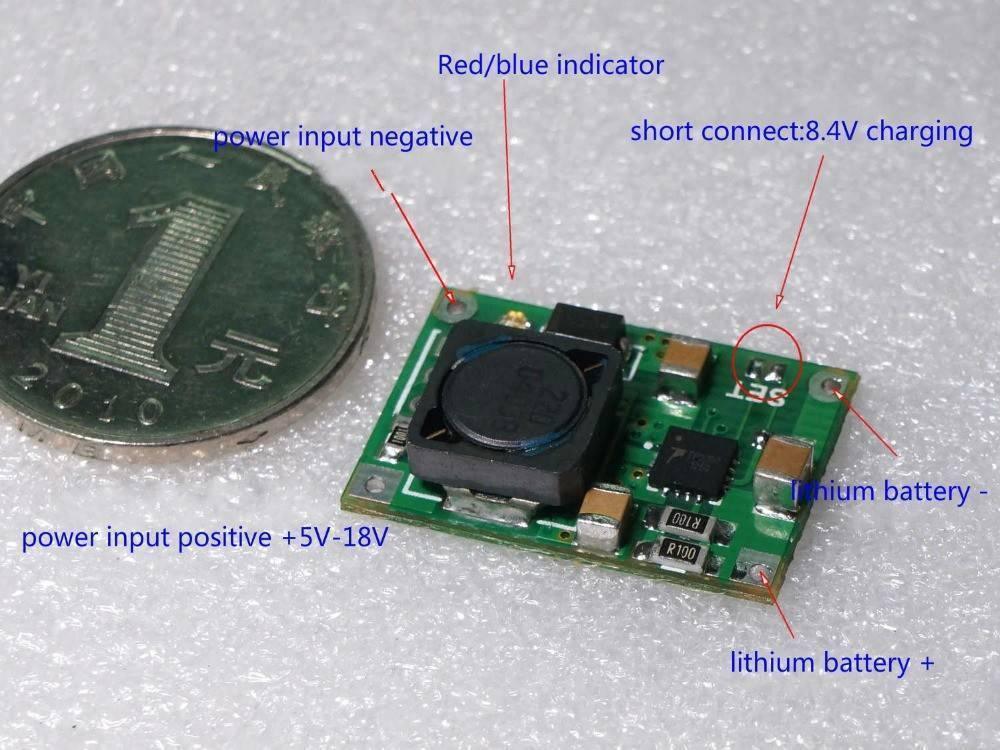 Hw-370 TP5100 2A Li Ion Battery Charger Module - a green circuit board with a black inductor, labeled solder pads, and a coin for scale.