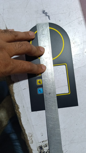 Hybride LCD Sticker Idm-7 Sticker For Graphical LCD Based Local Solar Inverter - shown as a black rectangular overlay with a circular cutout and button icons being measured by a ruler.