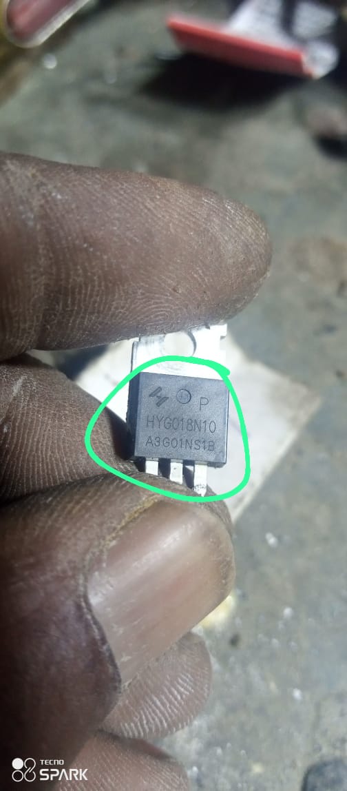 HYGO18N10 Controller 100V 322A Ev Controller 10kW | Digilog.pk - HYG018N10 controller, a close-up view of a black three-pin electronic transistor component held between fingers.