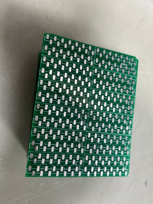 IC Base With Header SMD DSPIC30F2010 - a stack of green printed circuit boards featuring multiple rows of silver surface-mount contact pads.