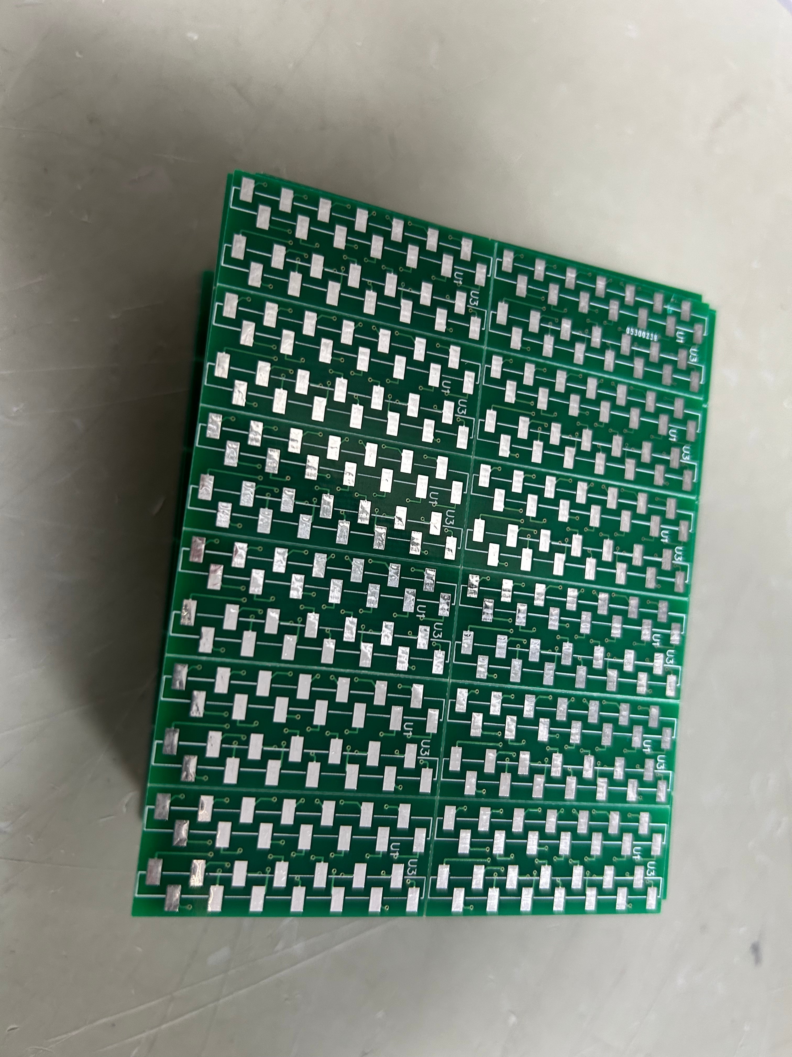 IC Base With Header SMD DSPIC30F2010 - a stack of green printed circuit boards featuring multiple rows of silver surface-mount contact pads.