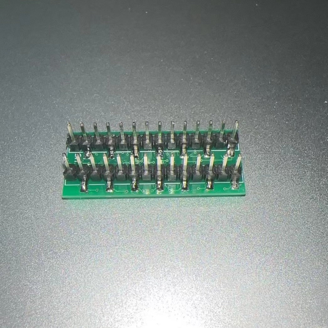 IC Base With Header SMD DSPIC30F2010 - a green rectangular PCB with two parallel rows of black-cased male pin headers soldered onto the surface.