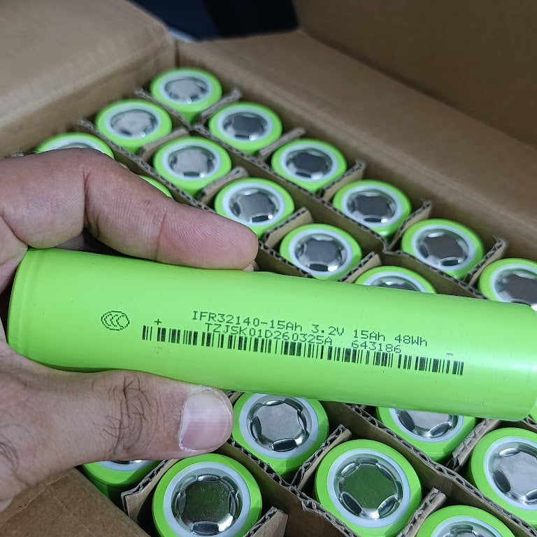 IFR32140 LiFePO4 Battery Cell 3.2V 15Ah 15A - Grade A Fresh Stock - hand holds a single light green cylindrical battery cell over a cardboard box filled with identical cells.