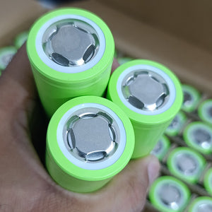 IFR32140 LiFePO4 Battery Cell 3.2V 15Ah 15A - Grade A Fresh Stock - close-up of three cylindrical lime-green battery cells held in a hand, showing the positive terminal ends.
