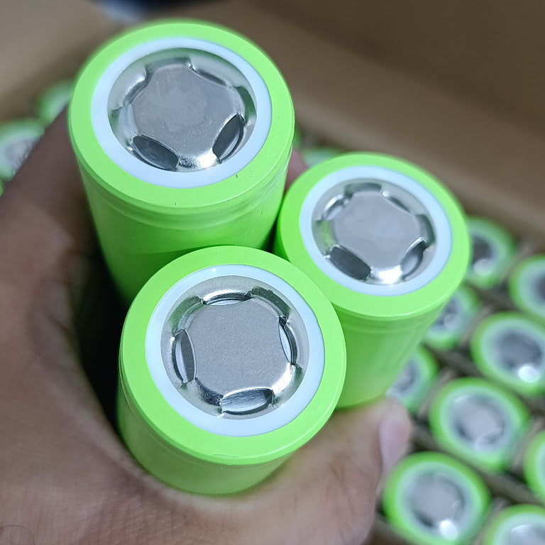 IFR32140 LiFePO4 Battery Cell 3.2V 15Ah 15A - Grade A Fresh Stock - close-up of three cylindrical lime-green battery cells held in a hand, showing the positive terminal ends.