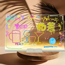 Transparent LED writing and message board with colourful drawings on a tabletop base