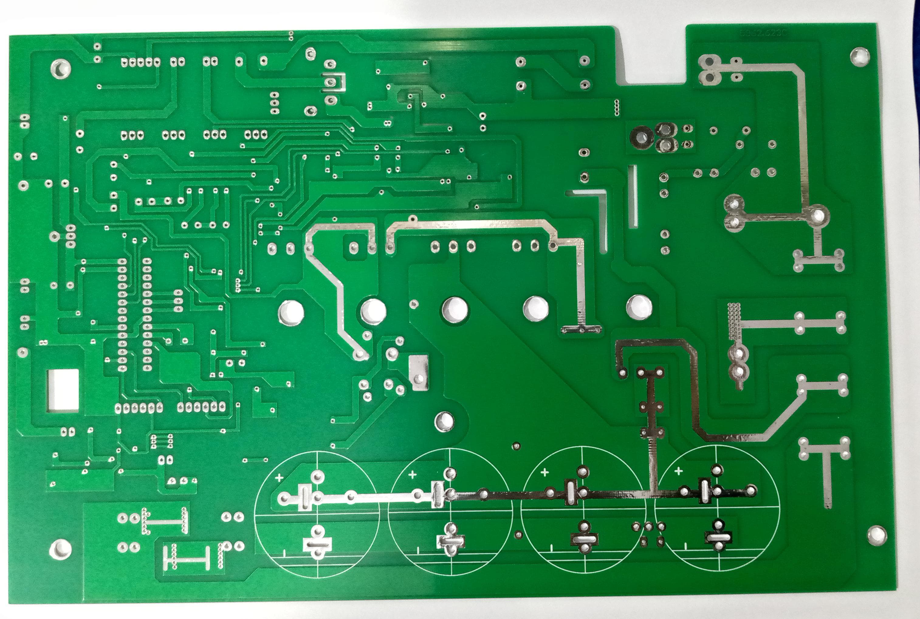 Imported 4 IGBT 5kVA Solar Inverter PCB With Pre Assembled SMD Components For Inverter Manufacturers Not Hobbyists - the green underside of a circuit board with visible copper traces, solder pads, and four circular markings.