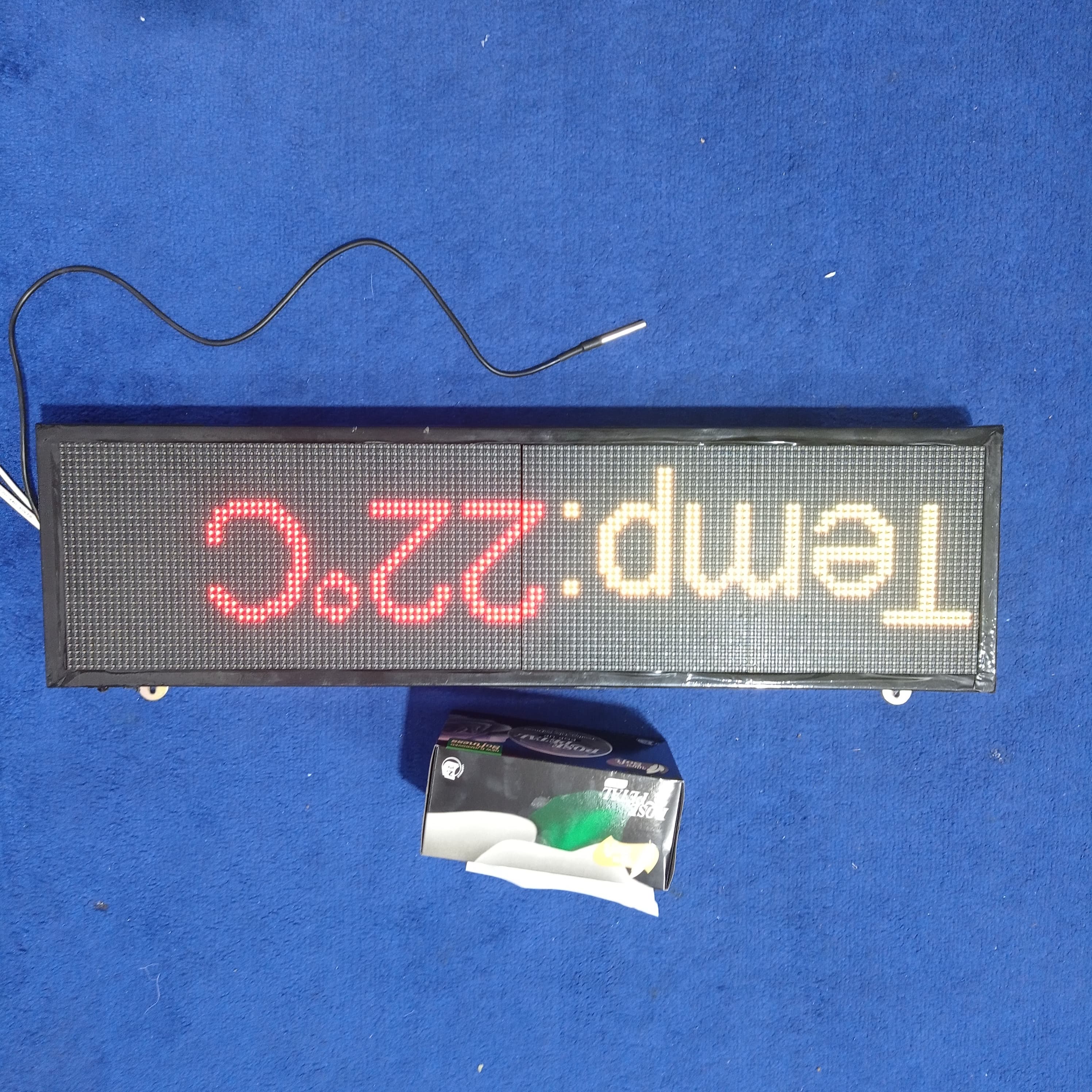 Industrial Clock With Temperature Display RGB Display - a rectangular LED screen displaying "Temp:22°C" with a black sensor probe and tissue box.