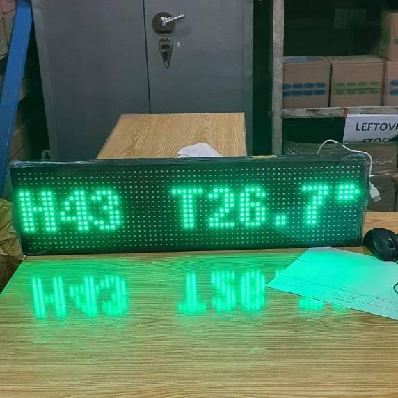 Industrial Grade 8 inch x 26inch Digital Hygrometer Display - green LED text reading H43 T26.7 on a wooden desk with a computer mouse nearby.