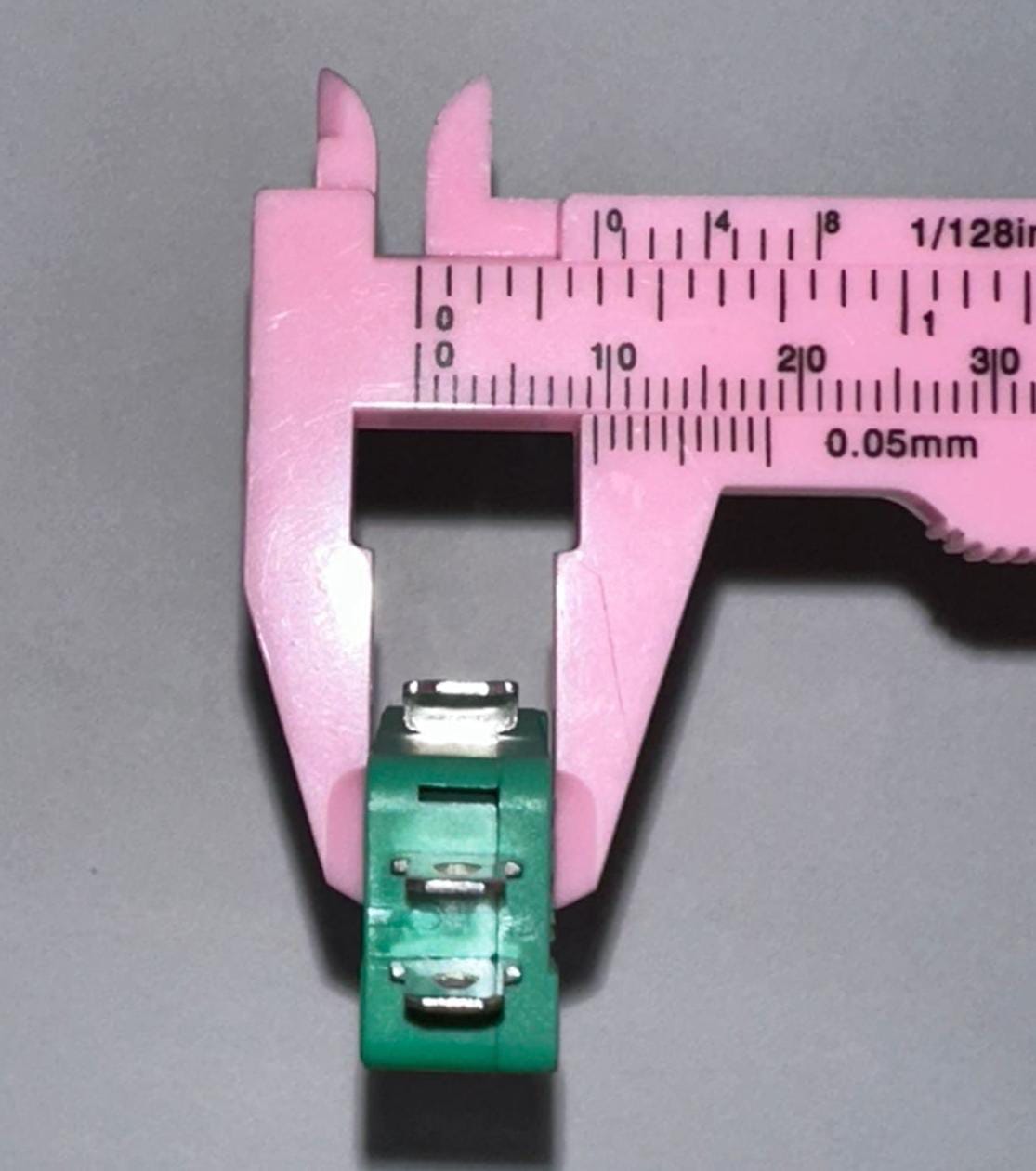Industrial Switches Micro Switch Spdt Momentary Travel Limit Switch 1NO1NC Lever Switches - shown in a close-up being measured by a pink plastic vernier caliper.