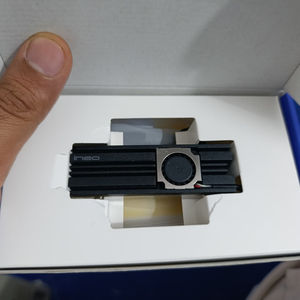 Ineo M.2 Heatsink SSD Cooler With 20mm Cooling Fan - Model C2600-II For Nvme 2280 SSD - shown inside its white cardboard packaging, featuring a black finned heatsink with an integrated cooling fan.