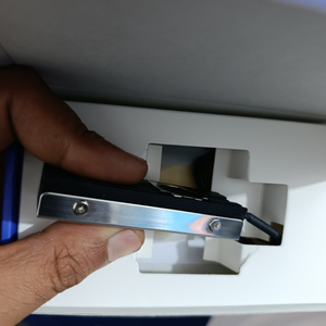 Ineo M.2 Heatsink SSD Cooler With 20mm Cooling Fan - Model C2600-II For Nvme 2280 SSD - close-up of the black and silver metal heatsink held by hand inside its white cardboard packaging insert.