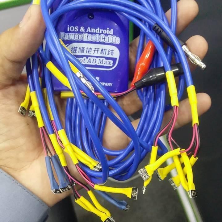 Ios & Android Power Boot Cable Pakistan - a purple control box with blue cables and various yellow-wrapped connectors held in a hand.