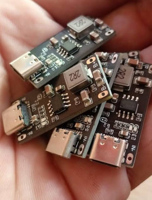 IP2312 Type C USB C Input High Current 3A 5V To 4.2V 4.35V Polymer Ternary Lithium Battery Fast Charging Board Type C USB C Input High Current 3A 5V - a close-up of several black rectangular circuit boards with USB-C ports and electronic components held in a hand.
