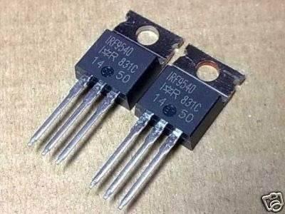 IRF9540 p Channel Power MOSFET - Buy Power MOSFET | Digilog.pk - two black, three-pin electronic components with metal mounting tabs arranged side-by-side on a brown surface.