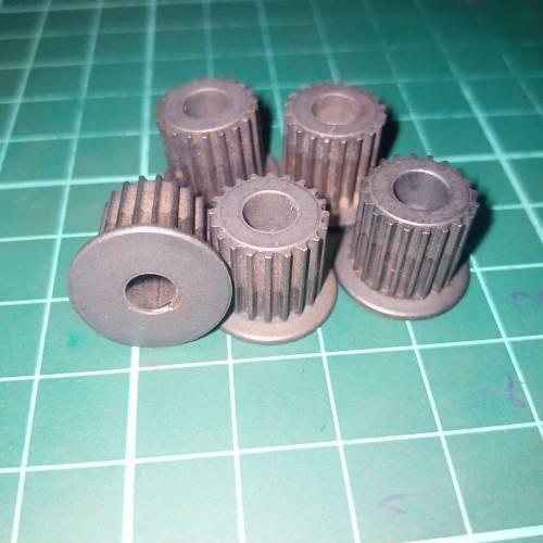 Japanese GT2 20 Teeth 5mm Bore Push Fit Pulley Timing Pulley - a group of five grey metal gear pulleys arranged on a green cutting mat.