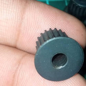 Japanese GT2 20 Teeth 5mm Bore Push Fit Pulley Timing Pulley - a close-up view of the black, circular, toothed pulley held between fingers.
