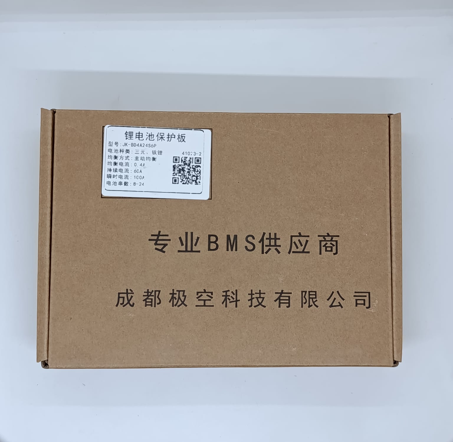 Jk 24S 60A Smart BMS With 400mA - shown inside a brown cardboard box with a product specification label and a QR code printed on the top lid.