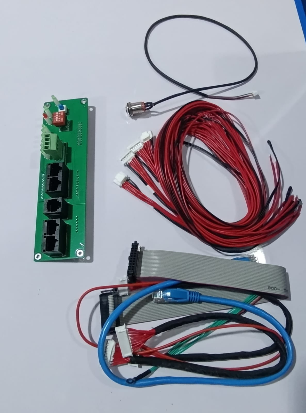 Jkbms PB1A16S15P Smart Inverter BMS 8s - 16S 24V 48V 150A Family Energy Storage LiFePO4/li-ion/lto - a green circuit board with four ports, a red switch, wiring harnesses, and cables.