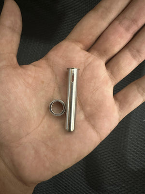 Kada 903D Tip Enclosure - shown as a silver-coloured metal tube with a small side slot and a separate metal ring held in a palm.