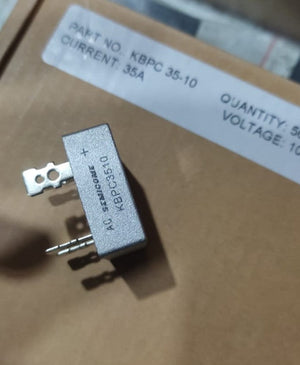 KBPC3510 Bridge Rectifier Diode - Single Phase, Metal Case, 1000V 35A - a silver metal-cased component with four terminal pins, shown in a close-up view resting on its cardboard packaging.