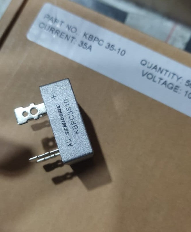 KBPC3510 Bridge Rectifier Diode - Single Phase, Metal Case, 1000V 35A - a silver metal-cased component with four terminal pins, shown in a close-up view resting on its cardboard packaging.