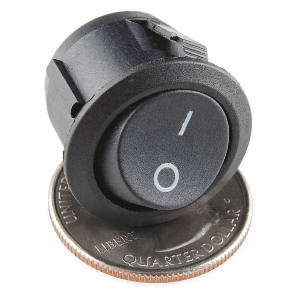 Kcd-107 Spst Round Rocker Switch Button - a black circular rocker switch with an on-off symbol, shown resting on top of a US quarter coin.