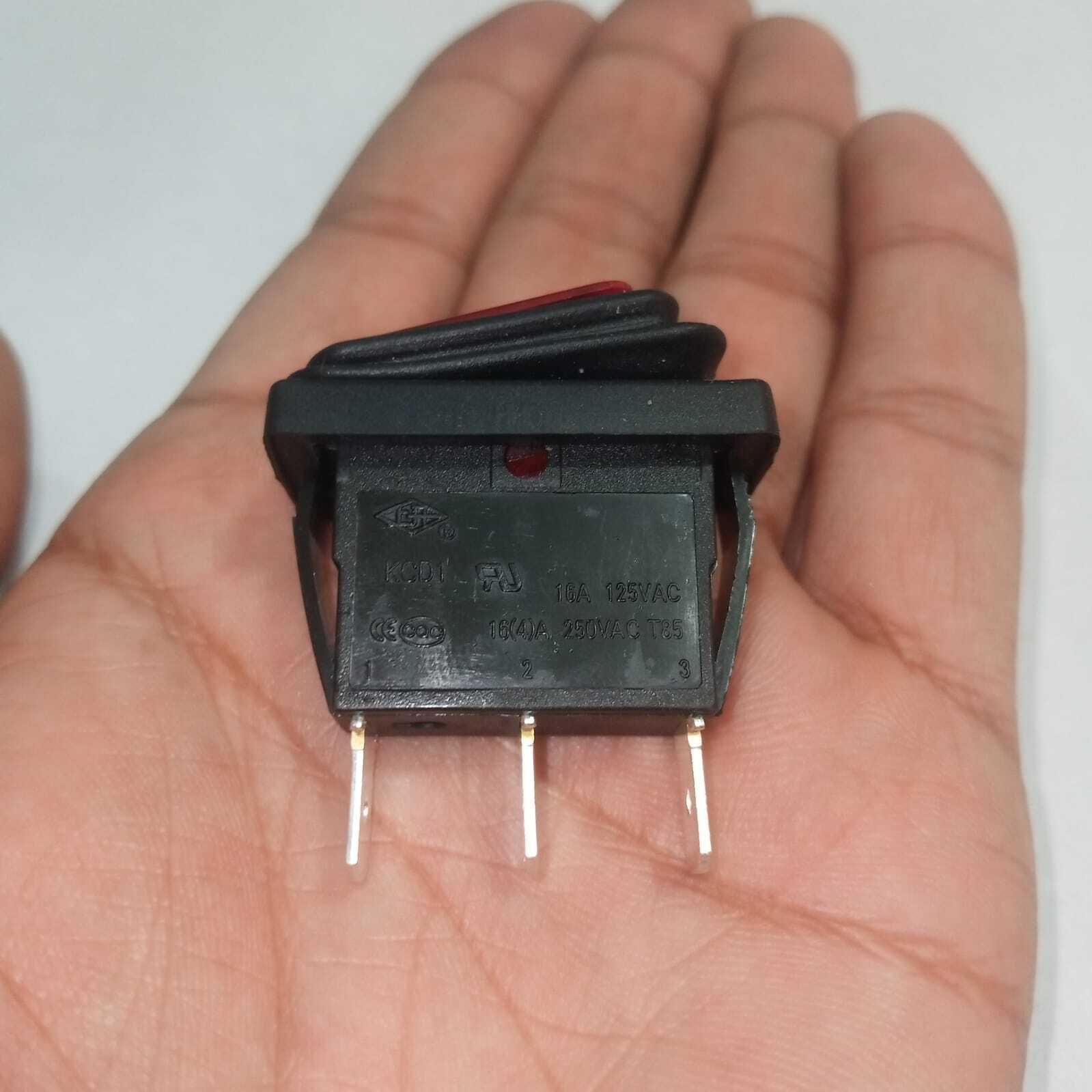 KCD3 Spdt Rocker Switch Waterproof - a black rectangular rocker switch with a red actuator and three metal pins held in a hand.