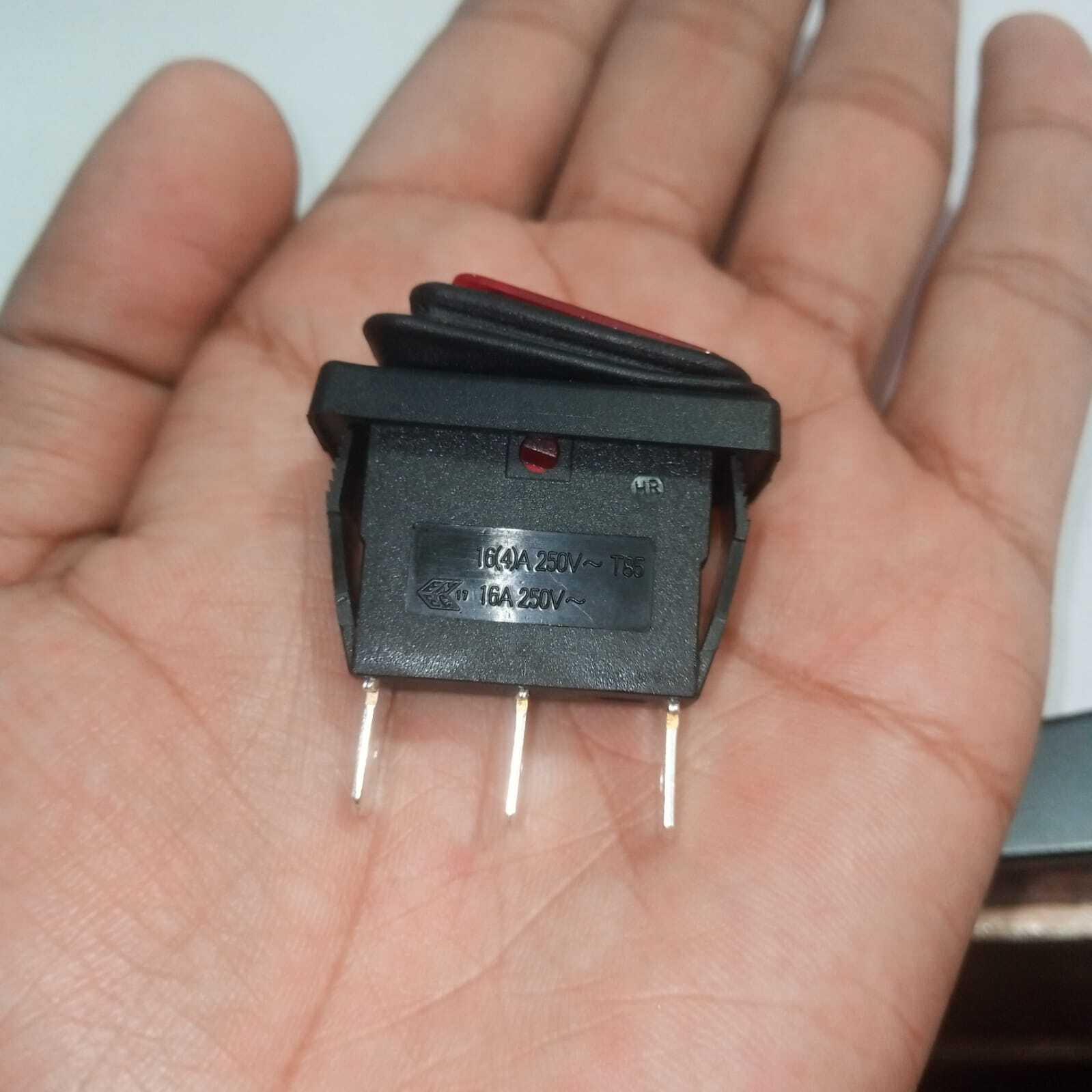 KCD3 Spdt Rocker Switch Waterproof - a black three-pin switch with a red actuator held in a hand, showing electrical specifications printed on the side.