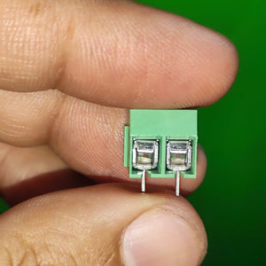 Kf 350 /kf 126 250V 10A 5mm Pitch Green Color 2 Pin Screw Terminal Connector Tblock - a close-up view held between fingers showing the green plastic housing and two metal wire entry ports.