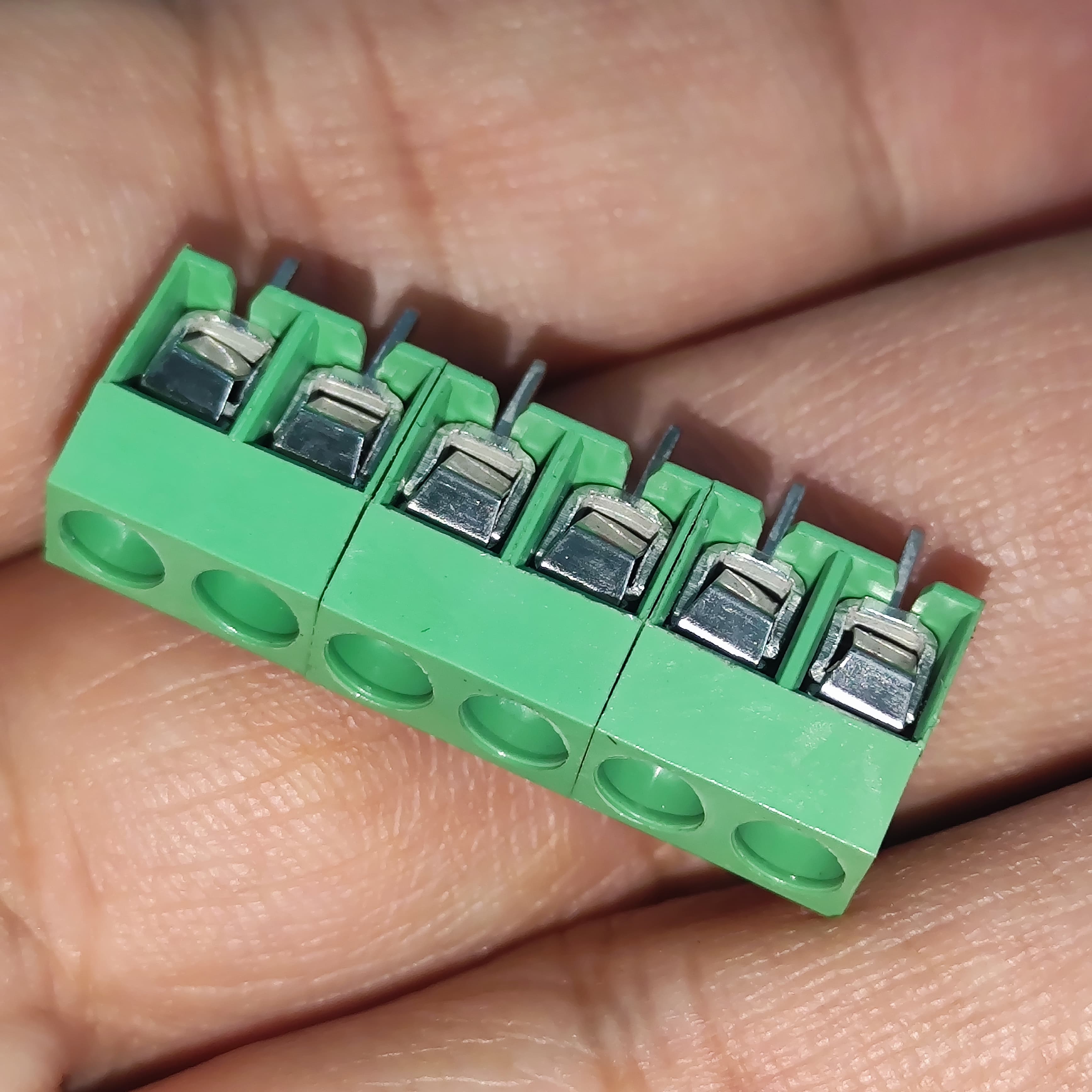 Kf 350 /kf 126 250V 10A 5mm Pitch Green Color 2 Pin Screw Terminal Connector Tblock - a 6-pin green screw terminal block held in a hand, showing the metal wire entry points and top screws.