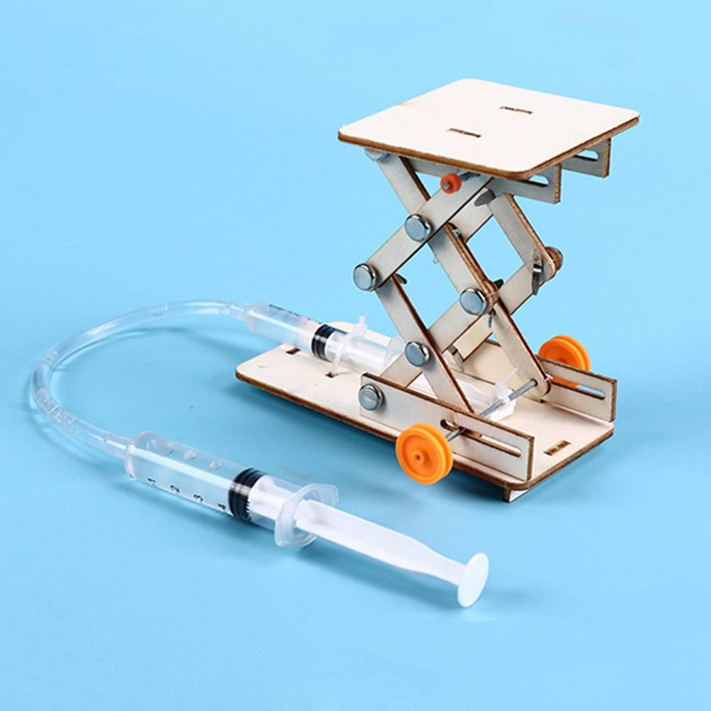 Kids DIY Hydraulic Lift Table Model Scientific Experiment Kit Educational STEM Toy - a wooden scissor lift mechanism connected by a plastic tube to a handheld syringe.