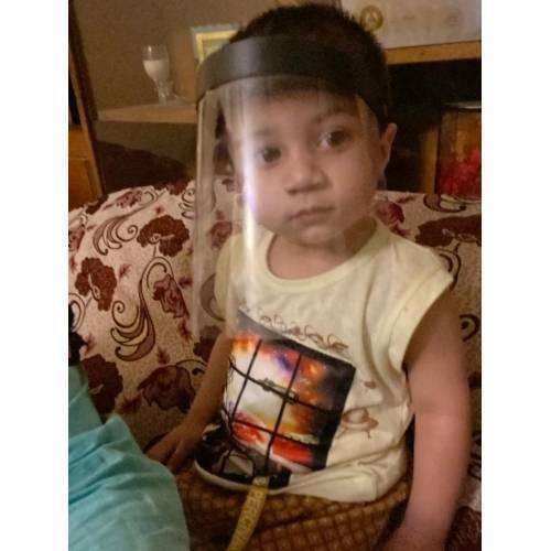 Kids Protective Face Sheild Professional Grade Face Mask - Shield Professional Grade Face Mask worn by a young child, featuring a clear plastic visor and a black adjustable headband.