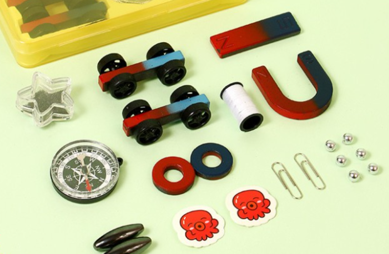 Kids STEM School Learning Magnet Power Kit - Science Experiment D - a collection of magnets, two toy cars, a compass, paperclips, metal balls, and octopus-themed stickers.