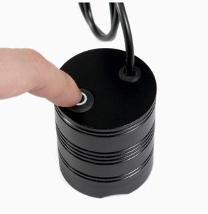 Koocu KC-UV1 Smart Curing UV Lamp Light - a finger pressing the power button on the black cylindrical top surface with a connected cable.