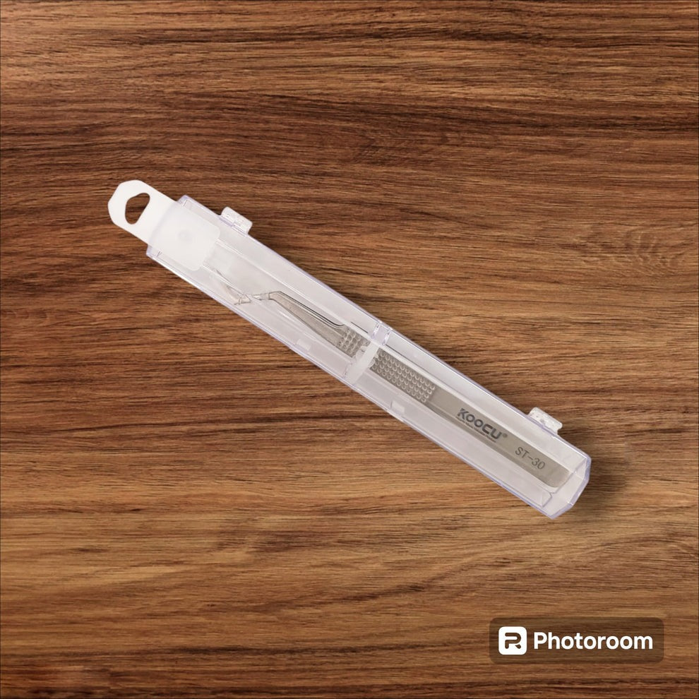 Koocu St-30 Non-magnetic Stainless Steel Precision Chip Placement Tweezer - tweezers inside a clear plastic storage case, positioned diagonally on a wood-grain surface.
