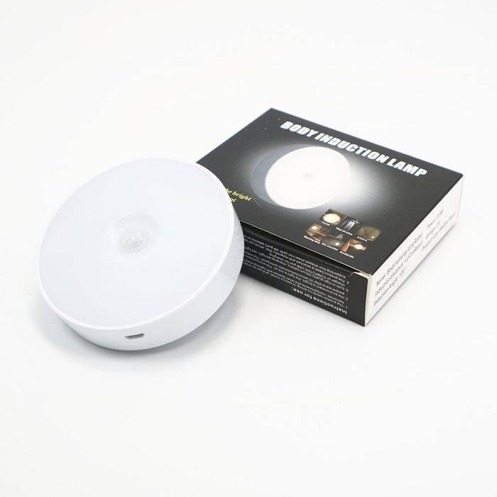 LED Body Induction Lamp Induction Night Light Warm White PIR Sensor - a round white motion sensor light with a visible charging port, shown next to its product packaging box.