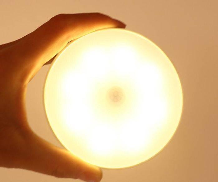 LED Body Induction Lamp Induction Night Light Warm White PIR Sensor - a round, warm white glowing light held in a hand, showing a small circular motion sensor in the center.