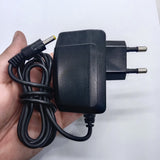 LG U+ 5V 2amp Power Adaptor Kecil Jack - a black wall-plug power supply with a long cable and a yellow-tipped barrel connector held in a hand.